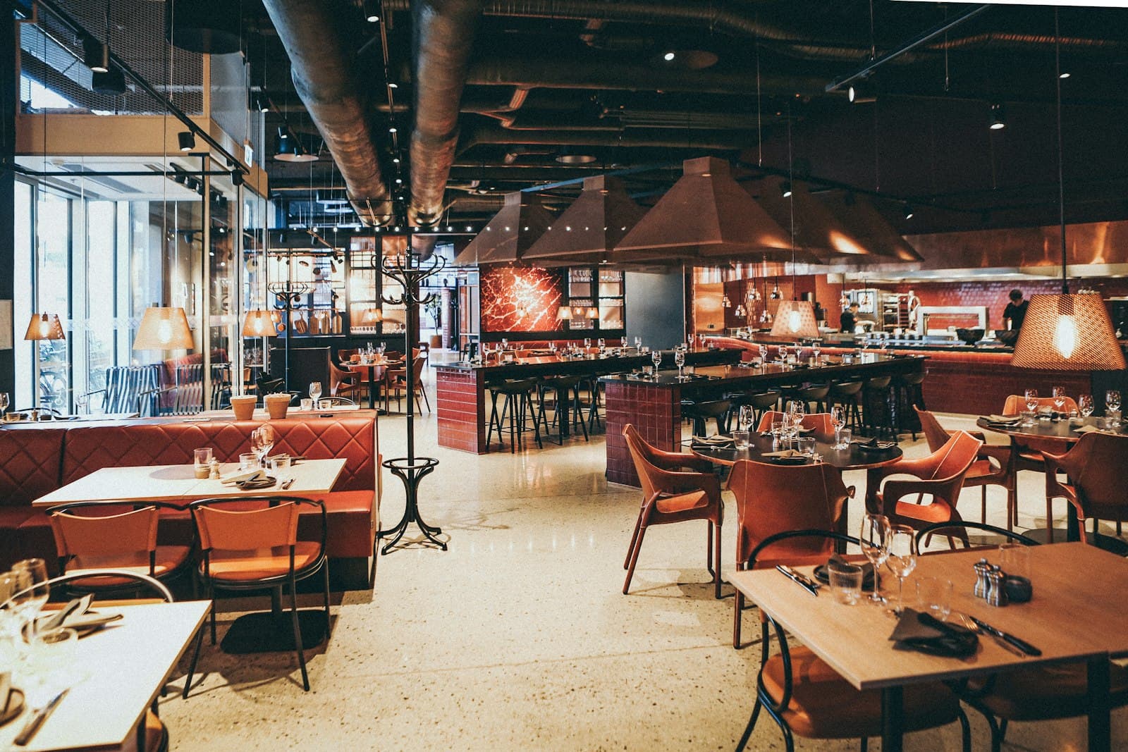 A quiet restaurant room lit by low warm lamps and set for dinner